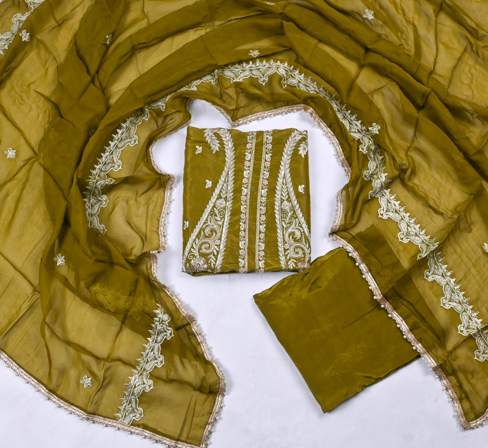 Green fabric with white embroidery on a white background