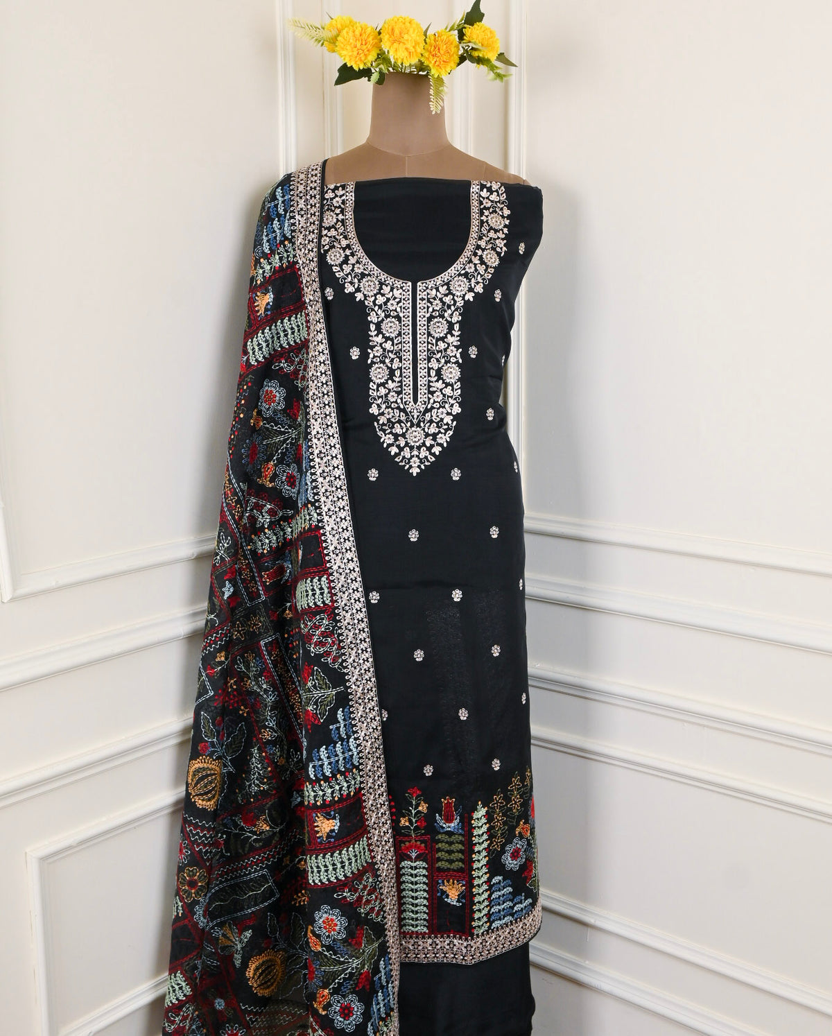 Black embroidered dress with a colorful dupatta on a white background
