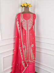 Red embroidered traditional outfit on a mannequin against a white wall.
