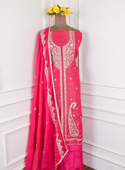 Pink traditional outfit with white embroidery on a mannequin against a white background