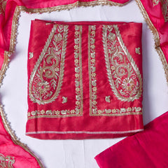 pink fabric with gold embroidery on a white background