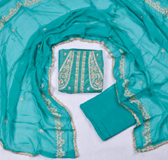 Turquoise fabric with gold embroidery on a white background