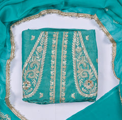 Teal fabric with gold embroidery on a white background